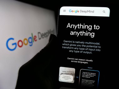 Stuttgart, Almanya - 12-14-2023: Yapay Zeka şirketi Google DeepMind 'ın web sayfası ile logo önünde cep telefonu tutan kişi. Telefon ekranının merkezine odaklan.