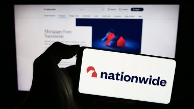 Stuttgart, Almanya - 12-14-2023: İnternet sayfası önünde üzerinde İngiliz Finans Kurumu İnşaat Toplumu logosu bulunan cep telefonu sahibi kişi. Telefon ekranına odaklan.