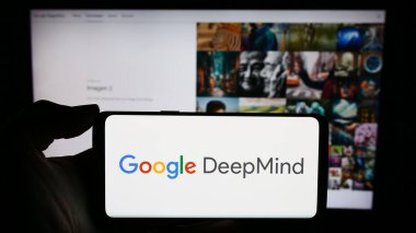 Stuttgart, Almanya - 12-14-2023: Yapay Zeka şirketi Google DeepMind 'ın logosu olan cep telefonu sahibi kişi iş sayfasının önünde. Telefon ekranına odaklan.