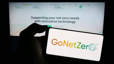 Stuttgart, Almanya - 12-14-2023: Singapur karbon yönetim şirketi GoNetZero 'nun logosuyla cep telefonu sahibi kişi iş sayfasının önünde. Telefon ekranına odaklan.