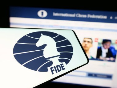 Stuttgart, Germany - 12-15-2023: Cellphone with logo of organisation International Chess Federation (FIDE) in front of website. Focus on center of phone display. clipart