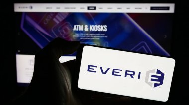 Stuttgart, Almanya - 12-17-2023: Web sitesi önünde ABD 'li slot makinesi şirketi Everi Holding Inc.' in logosuna sahip kişi. Telefon ekranına odaklan.