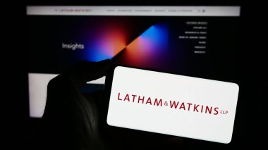 Stuttgart, Almanya - 12-17-2023: Amerikan hukuk firması Latham ve Watkins LLLP 'nin (LW) logosuna sahip cep telefonu sahibi kişi iş sayfasının önünde. Telefon ekranına odaklan.