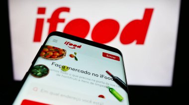 Stuttgart, Almanya - 12-18-2023: İş logosu önünde Brezilya gıda siparişi ve teslimat şirketi iFood 'un web sitesi bulunan cep telefonu. Telefon ekranının sol üst kısmına odaklan.