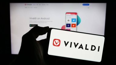 Stuttgart, Almanya - 12-18-2023: Norveçli web tarayıcı şirketi Vivaldi Technologies AS 'nin logosuyla cep telefonu sahibi kişi iş sayfasının önünde. Telefon ekranına odaklan.