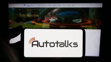 Stuttgart, Almanya - 12-18-2023: İsrailli otomotiv teknoloji şirketi Autotalks Lt. nin logosuna sahip akıllı telefon sahibi kişi web sitesinin önünde. Telefon ekranına odaklan.