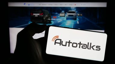 Stuttgart, Almanya - 12-18-2023: İsrailli otomotiv teknoloji şirketi Autotalks Lt. nin logosunun bulunduğu cep telefonu sahibi kişi iş sayfasının önünde. Telefon ekranına odaklan.