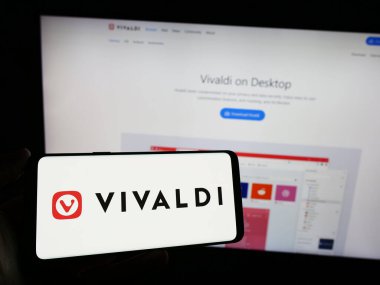 Stuttgart, Almanya - 12-18-2023: Web sayfası önünde Norveç web tarayıcı şirketi Vivaldi Technologies AS 'nin logosuna sahip cep telefonu sahibi kişi. Telefon ekranına odaklan.