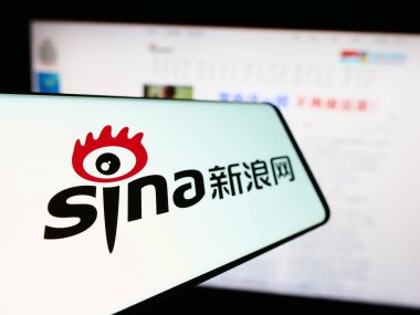 Stuttgart, Germany - 12-19-2023: Mobile phone with logo of Chinese technology company Sina Corporation in front of business website. Focus on center-left of phone display. clipart