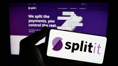 Stuttgart, Almanya - 12-19-2023: ABD 'li fintech şirketi Splitit Ltd.' nin logosuna sahip akıllı telefon sahibi kişi web sitesinin önünde. Telefon ekranına odaklan.