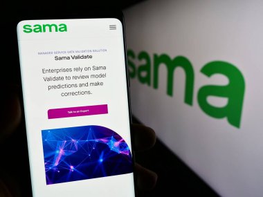 Stuttgart, Almanya - 12-19-2023: ABD 'li Samasource Impact Sourcing Inc. (Sama) şirketinin web sayfası ile akıllı telefon sahibi kişi logonun önünde. Telefon ekranının merkezine odaklan.