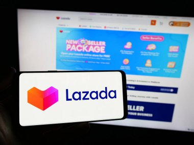 Stuttgart, Almanya - 12-20-2023: İnternet sitesi önünde Asyalı e-ticaret şirketi Lazada Group 'un logosuna sahip kişi. Telefon ekranına odaklan.