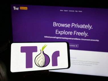 Stuttgart, Almanya - 12-20-2023: İnternet sitesinin önünde anonim iletişim yazılımı logosu olan akıllı telefon sahibi kişi. Telefon ekranına odaklan.