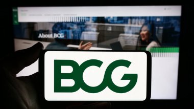 Stuttgart, Almanya - 12-20-2023: ABD 'li şirket Boston Consulting Group Inc. (BCG)' nin logosuna sahip akıllı telefon sahibi kişi web sitesi önünde. Telefon ekranına odaklan.