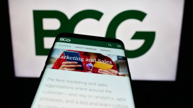 Stuttgart, Almanya - 12-20-2023: ABD 'li şirket Boston Consulting Group Inc. (BCG)' nin web sayfası ile akıllı telefon sahibi kişi logonun önünde. Telefon ekranının merkezine odaklan.