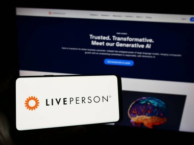 Stuttgart, Almanya - 12-20-2023: İş sayfasının önünde sohbet şirketi LivePerson Inc. 'in logosuna sahip cep telefonu sahibi kişi. Telefon ekranına odaklan.