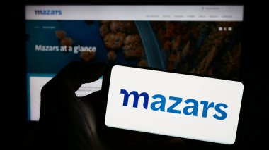 Stuttgart, Almanya - 12-22-2023: Uluslararası muhasebe şirketi Mazars Group 'un logosuyla cep telefonu tutan kişi iş sayfası önünde. Telefon ekranına odaklan.