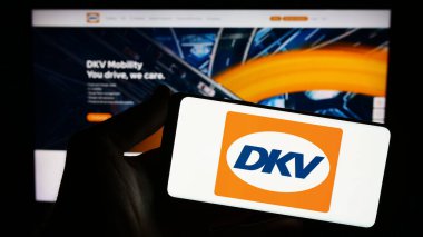 Stuttgart, Almanya - 11-02-2023: İnternet sitesi önünde Alman B2B ödeme şirketi DKV Mobility 'nin logosuna sahip kişi. Telefon ekranına odaklan.