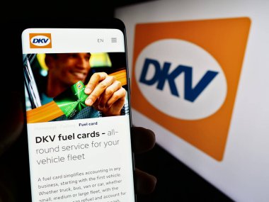 Stuttgart, Almanya - 11-02-2023: Logo önünde Alman B2B ödeme şirketi DKV Mobility 'nin web sayfası ile cep telefonu tutan kişi. Telefon ekranının merkezine odaklan.