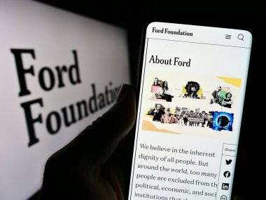 Stuttgart, Almanya - 11-02-2023: ABD yardım kuruluşu Ford Foundation 'ın web sitesi ile logo önünde cep telefonu tutan kişi. Telefon ekranının merkezine odaklan.