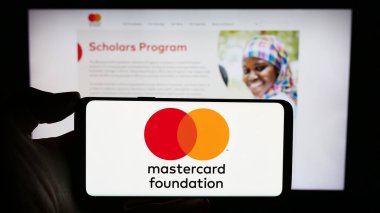 Stuttgart, Almanya - 11-02-2023: Kanadalı hayır kurumu Mastercard Foundation 'ın logosunu web sayfası önünde tutan kişi. Telefon ekranına odaklan.