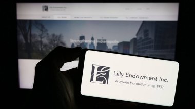 Stuttgart, Almanya - 11-02-2023: İnternet sayfasının önünde Amerikan vakfı Lilly Endowment Inc. 'in logosu olan cep telefonu sahibi. Telefon ekranına odaklan.