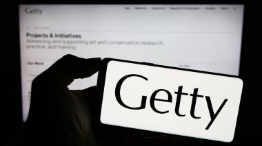 Stuttgart, Almanya - 11-03-2023: Web sayfası önünde ABD sanat vakfı logosu olan cep telefonu sahibi kişi. Telefon ekranına odaklan.
