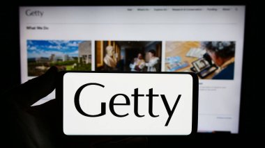 Stuttgart, Almanya - 11-03-2023: ABD sanat vakfının logosu olan akıllı telefon sahibi kişi J. Paul Getty Trust web sitesinin önünde. Telefon ekranına odaklan.
