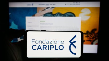 Stuttgart, Almanya - 11-03-2023: İtalyan hayır kurumu Fondazione Cariplo 'nun logosuna sahip kişi web sitesinin önünde. Telefon ekranına odaklan.