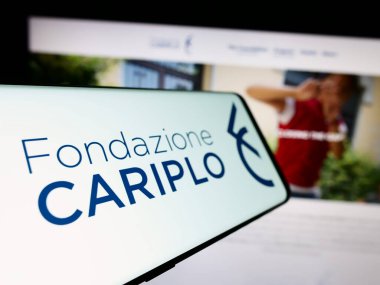 Stuttgart, Germany - 11-03-2023: Cellphone with logo of Italian charitable foundation Fondazione Cariplo in front of website. Focus on center-left of phone display. clipart