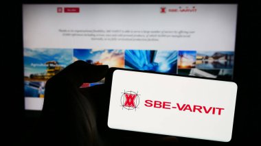 Stuttgart, Almanya - 11-03-2023: Üzerinde İtalyan mekanik bağlanma şirketi SBE-VARVIT S.p.A. 'nın logosu bulunan cep telefonu sahibi kişi web sayfası önünde. Telefon ekranına odaklan.