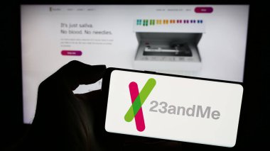 Stuttgart, Almanya - 11-03-2023: Amerikan biyoteknoloji şirketi 23andMe Inc. 'in logosu olan cep telefonu sahibi kişi iş sayfasının önünde. Telefon ekranına odaklan.