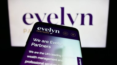 Stuttgart, Almanya - 11-06-2023: İngiliz finans hizmetleri şirketi Evelyn Partners 'ın web sitesi ile birlikte iş logosu önünde cep telefonu. Telefon ekranının sol üst kısmına odaklan.