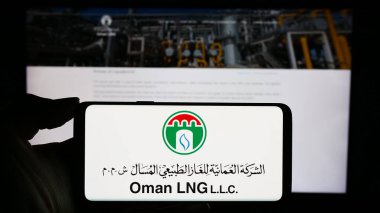 Stuttgart, Almanya - 11-06-2023: Omani 'nin sıvılaştırılmış doğalgaz şirketi Umman LNG' nin logosunu taşıyan cep telefonu sahibi iş sayfası önünde. Telefon ekranına odaklan.