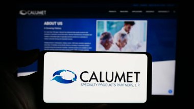 Stuttgart, Almanya - 11-06-2023: İş sayfası önünde ABD 'li Calumet Specialty Products Partners LP logosuna sahip kişi. Telefon ekranına odaklan.