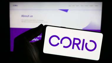 Stuttgart, Almanya - 11-06-2023: Yenilenebilir enerji yatırım şirketi Corio Generation Limited 'in logosuna sahip akıllı telefon sahibi kişi web sitesinin önünde. Telefon ekranına odaklan.