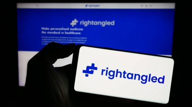 Stuttgart, Almanya - 11-06-2023: İnternet sayfasının önünde İngiliz çevrimiçi eczane şirketi Rightangled Limited 'in logosuna sahip cep telefonu sahibi kişi. Telefon ekranına odaklan.