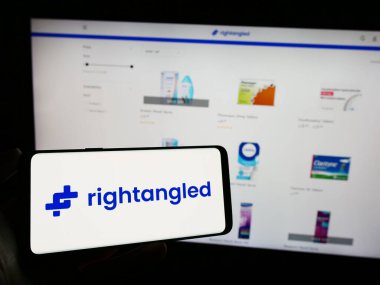 Stuttgart, Almanya - 11-06-2023: İngiliz çevrimiçi eczane şirketi Rightangled Limited 'in logosunu taşıyan kişi iş sayfasının önünde. Telefon ekranına odaklan.