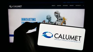 Stuttgart, Almanya - 11-06-2023: ABD 'li Calumet Specialty Products Partners' ın logosunun bulunduğu akıllı telefonu web sitesinin önünde tutan kişi. Telefon ekranına odaklan.