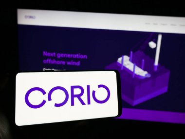 Stuttgart, Almanya - 11-06-2023: Yenilenebilir enerji yatırım şirketi Corio Generation Limited 'in logosuna sahip cep telefonu sahibi kişi web sayfasının önünde. Telefon ekranına odaklan.