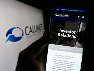 Stuttgart, Almanya - 11-06-2023: ABD 'li Calumet Specialty Products Partners' ın web sayfası ile logo önünde cep telefonu tutan kişi. Telefon ekranının merkezine odaklan.