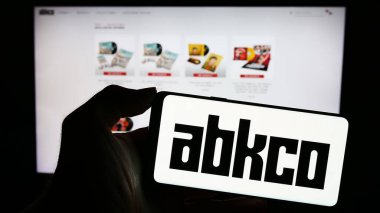 Stuttgart, Almanya - 11-07-2023: ABD 'li plak şirketi ABKCO Music Records Inc.' in logosuyla cep telefonu tutan kişi iş sayfasının önünde. Telefon ekranına odaklan.