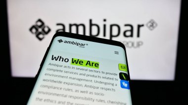 Stuttgart, Almanya - 11-07-2023: Brezilyalı çevre hizmetleri şirketi Ambipar Group 'un web sitesine sahip akıllı telefon iş logosu önünde. Telefon ekranının sol üst kısmına odaklan.