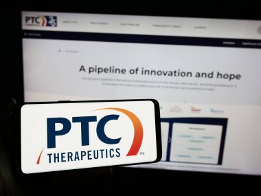 Stuttgart, Almanya - 11-07-2023: İnternet sitesi önünde üzerinde ABD 'li ilaç şirketi PTC Therapeutics Inc.' in logosu bulunan kişi. Telefon ekranına odaklan.