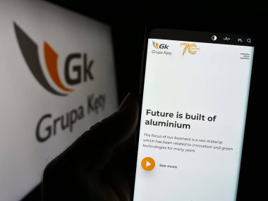 Stuttgart, Almanya - 11-07-2023: Polonyalı alüminyum şirketi Grupa Kety S.A. 'nın web sitesi ile logo önünde cep telefonu tutan kişi. Telefon ekranının merkezine odaklan.