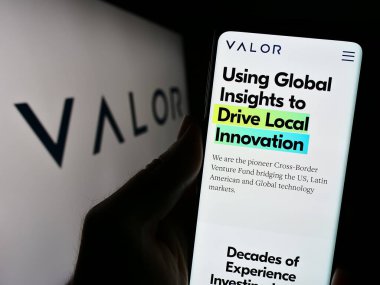 Stuttgart, Almanya - 11-07-2023: ABD 'li yatırım şirketi Valor Capital Group LLC' nin web sitesiyle logo önünde cep telefonu tutan kişi. Telefon ekranının merkezine odaklan.