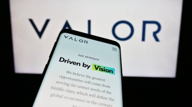 Stuttgart, Germany - 11-07-2023: Smartphone with webpage of US investment company Valor Capital Group LLC in front of business logo. Focus on top-left of phone display. clipart