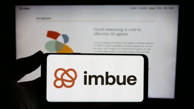 Stuttgart, Almanya - 11-07-2023: ABD yapay zeka (AI) araştırma şirketi Imbue 'nun logosuna sahip akıllı telefon sahibi kişi web sitesi önünde. Telefon ekranına odaklan.