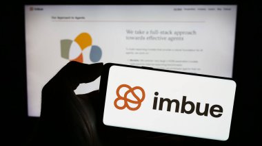 Stuttgart, Almanya - 11-07-2023: Üzerinde Amerikan Yapay Zeka (AI) araştırma şirketi Imbue 'nun logosu bulunan cep telefonu sahibi kişi web sayfasının önünde. Telefon ekranına odaklan.