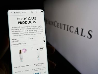 Stuttgart, Almanya - 11-08-2023: Logonun önünde kozmetik şirketi SkinCeuticals 'ın (L' Oreal) web sayfası ile akıllı telefon tutan kişi. Telefon ekranının merkezine odaklan.